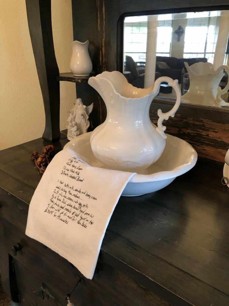 hand written recipe on a tea towel with white water pitcher with sentiment