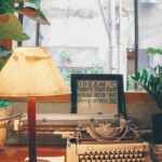 white typewriter beside table lamp