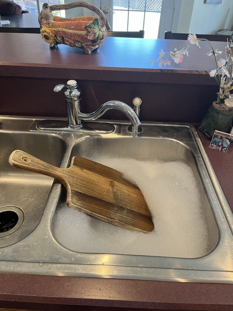 cleaning a cutting board with soapy water