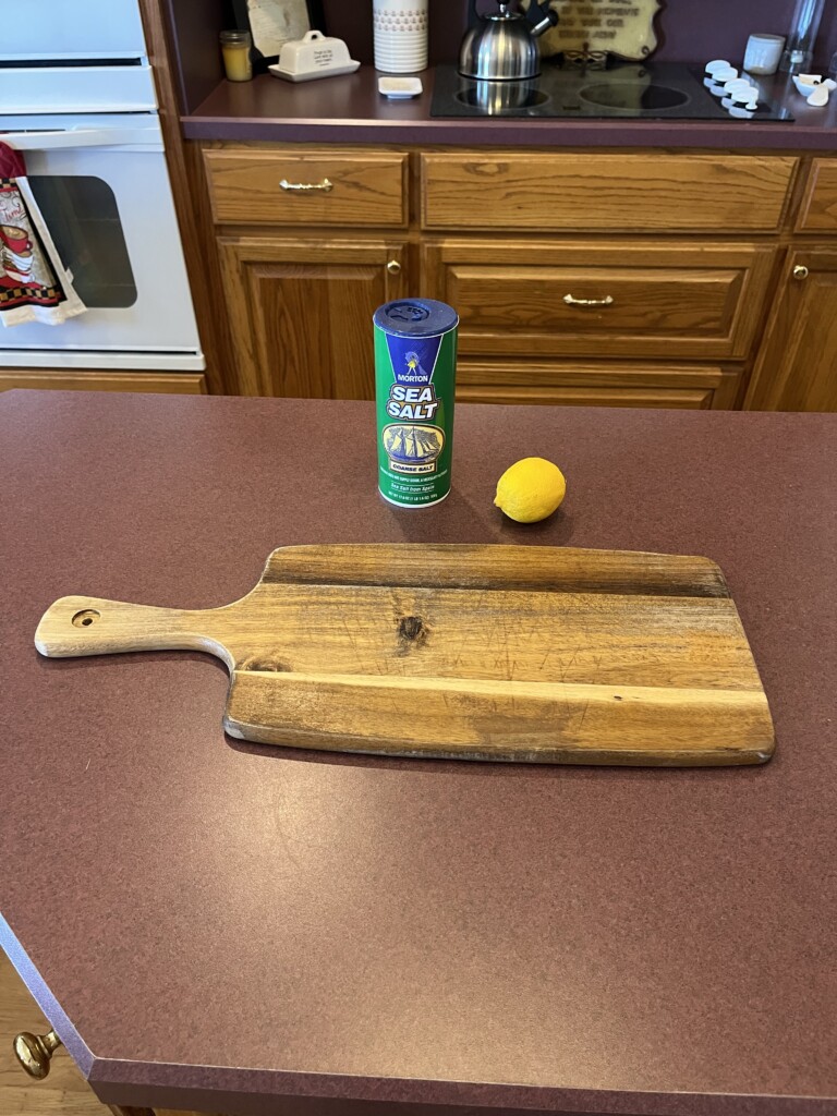 cleaning a cutting board with a lemon and salt