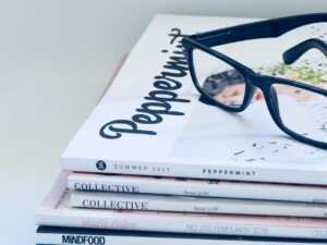photo of eyeglasses on top of magazines drop to save money