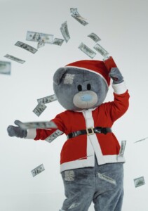 a teddy bear mascot in santa claus costume using a money gun showing how to save money