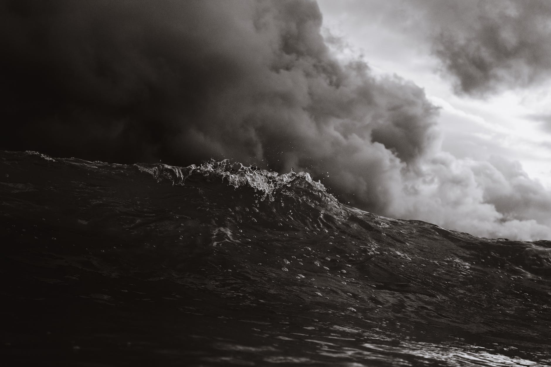 grayscale photo of body of waves dark storm