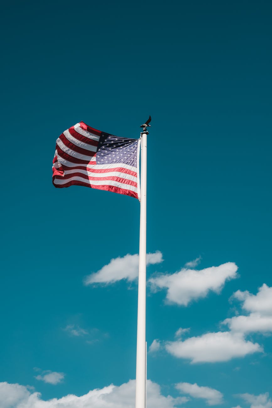 american flag on mast against blue sky