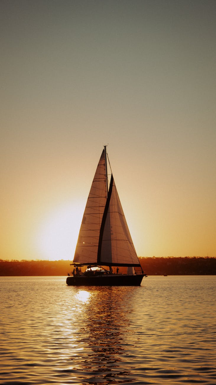yacht or boat sailing on river at sunset